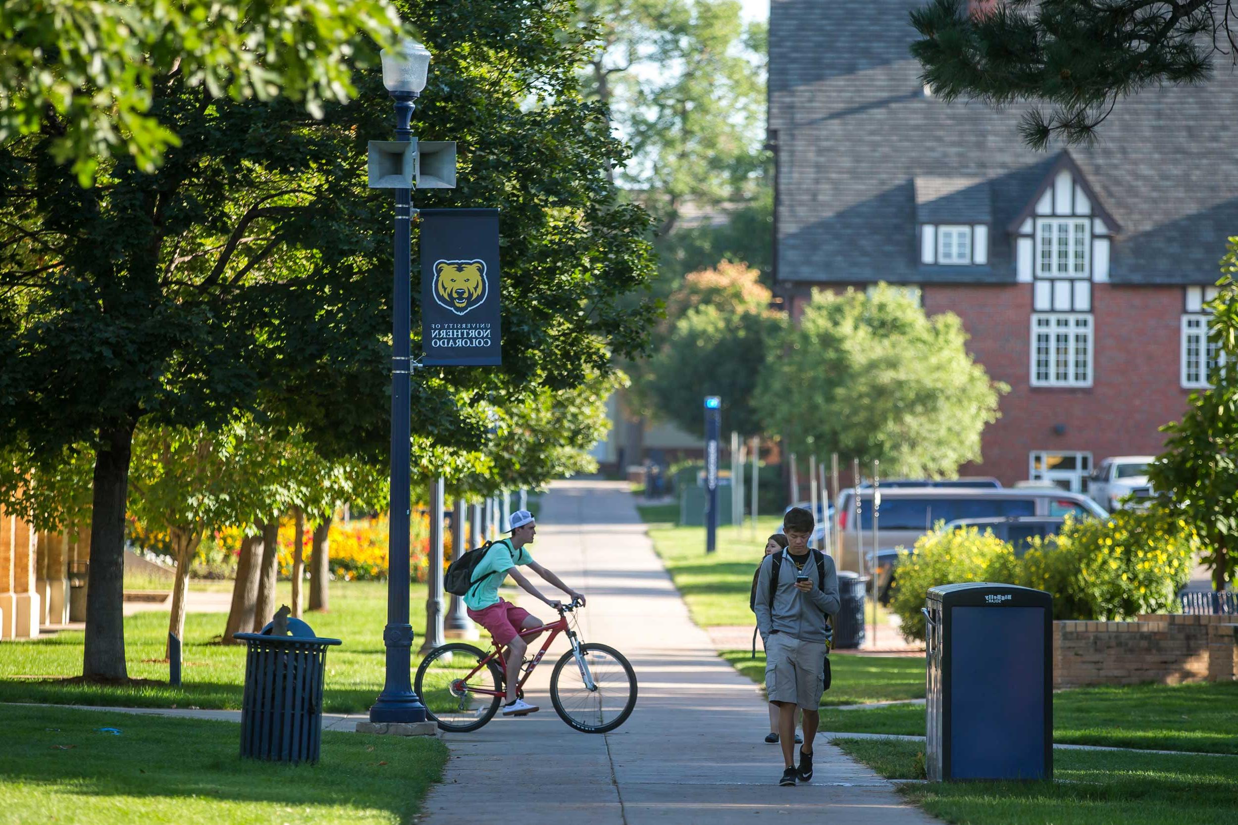 Student riding bike on campus.